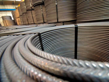 Many coils of steel bar tied up with black baling strip.